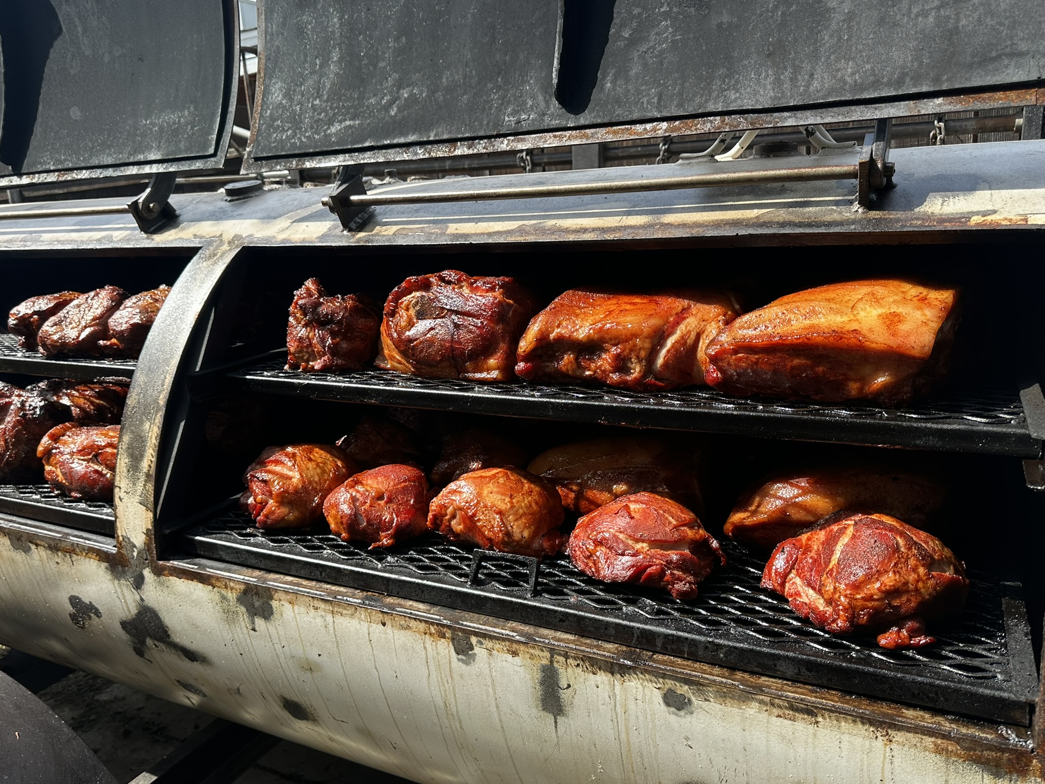Offset smoker loaded with slow-cooking meats